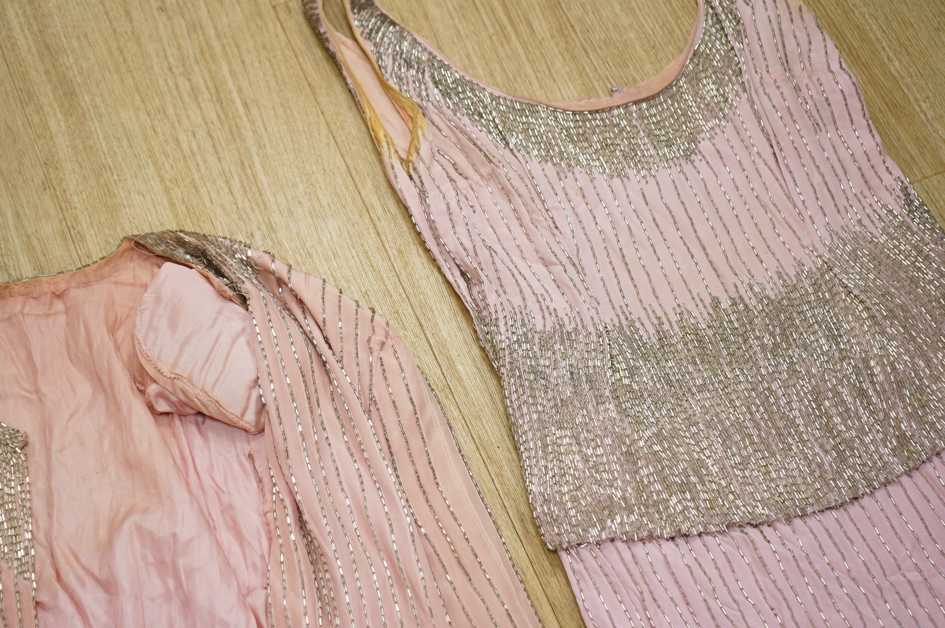 A mid to late 20th century pink and silver beaded evening dress-120cm long, with matching jacket, together with a green net beaded full length evening dress with mushroom lining and back split.